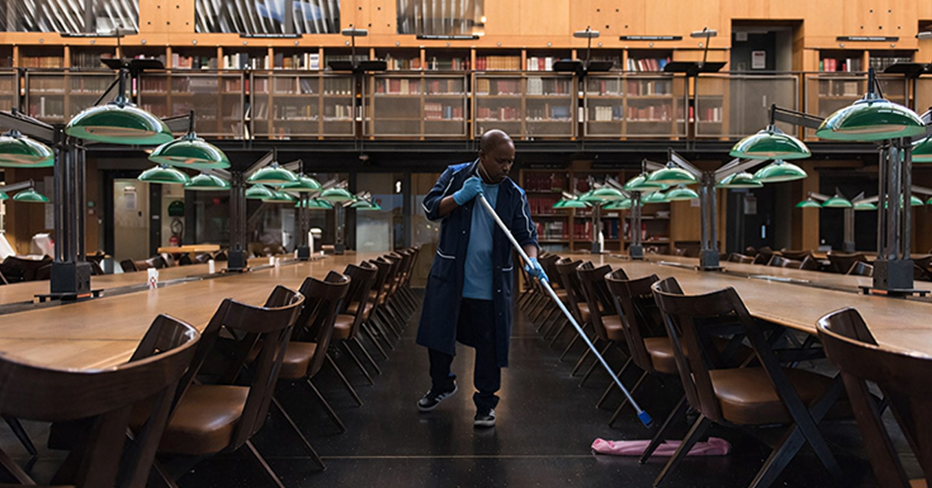 hommes Agent d'entretien nettoyant le sol d'une grande bibliothèque